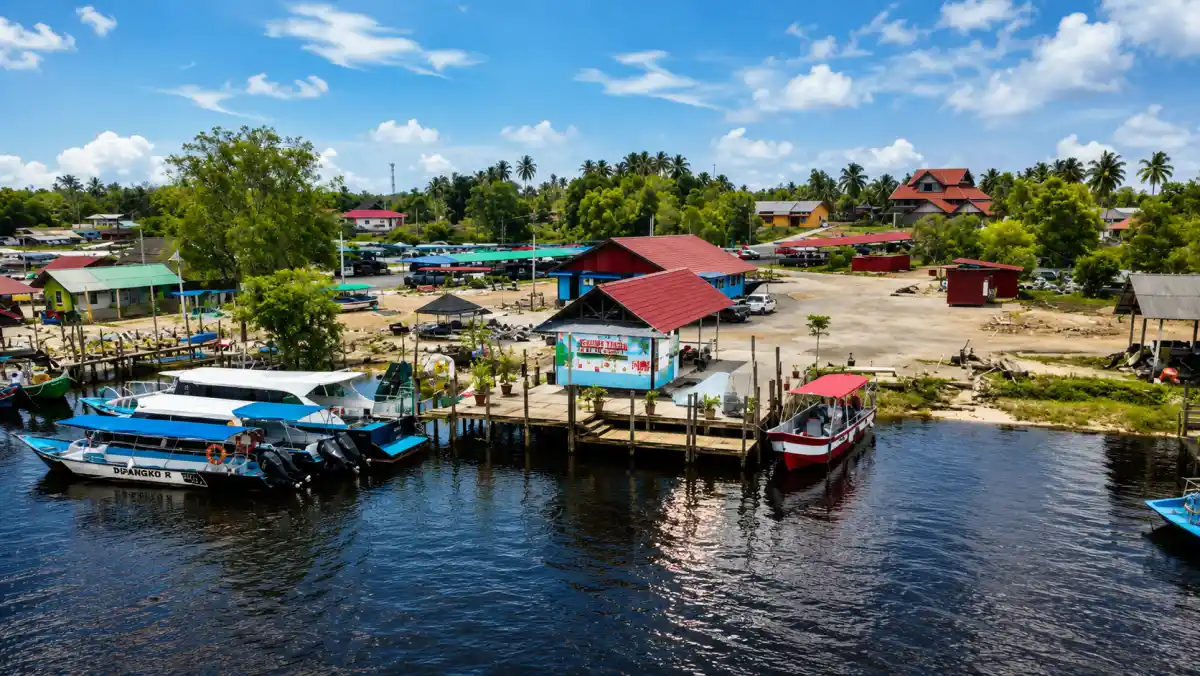 Boats at a coastal jetty in Terengganu with travellers boarding for the islands